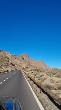 Teide Dağı 'nın muhteşem manzarası, Tenerife' nin ikonik volkanik volkanı, parlak mavi gökyüzünün altındaki engebeli volkanik arazisiyle gökyüzünde yükseliyor..