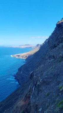 Degollada del Perchel 'in çarpıcı panoramik manzarası, Tenerife' de engebeli uçurumlar, aşağıdaki okyanus ve yukarıdaki parlak mavi gökyüzü, doğa aşıkları ve kaşifler için mükemmel..