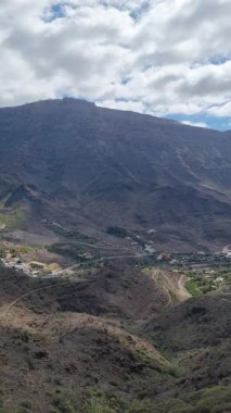 Tenerife 'deki El Molino de Viento' nun nefes kesici manzarası, engebeli dağların içine yerleşmiş, aşağıdaki vadide küçük bir köy, berrak mavi bir gökyüzü tarafından çerçevelenmiş..