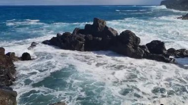 Tenerife, Charco del Viento 'nun canlı ve dingin bir kıyı şeridi. Okyanus engebeli volkanik kıyılara çarpıyor ve adaların vahşi güzelliğini gösteriyor..