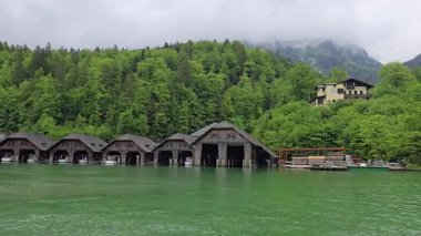 Almanya 'nın Bavyera Alpleri' ndeki Berchtesgaden yakınlarındaki Knigssee Gölü 'ndeki ahşap tekne barakalarının yanından geçen tekne gezisi.