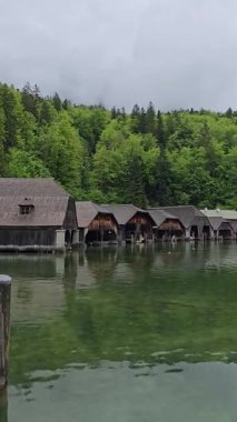 Geleneksel kayıkhaneler Berchtesgaden 'deki Koenigssee Gölü' nün sakin kıyılarında sisli Bavyera Alpleri ve sık ormanlarla kaplı büyülü bir dağ manzarası yaratıyor.