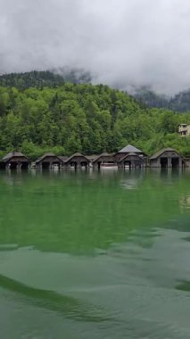 Geleneksel kayıkhaneler Berchtesgaden 'deki Koenigssee Gölü' nün sakin kıyılarında sisli Bavyera Alpleri ve sık ormanlarla kaplı büyülü bir dağ manzarası yaratıyor.