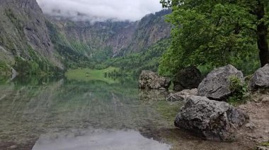 Bavyera Alplerinde gizlenen Obersee, kristal berrak su, alp sessizliği ve el değmemiş manzaralar sunuyor. Yukarı Bavyera 'da sakin bir dağ sığınağı.