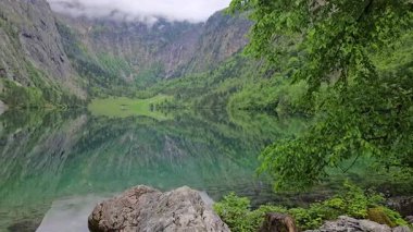 Bavyera Alplerinde yer alan Obersee Gölü 'nün huzurlu güzelliği, berrak suları etrafındaki dağları ve yemyeşil alanları yansıtıyor.. 