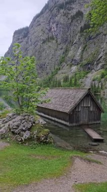 Berchtesgaden Ulusal Parkı, Bavyera, Almanya 'daki Berchtesgaden Ulusal Parkı' ndaki yüksek uçurumlar ve yemyeşil dağlarla çevrili, Obersee Gölü yakınlarındaki Idyllic ahşap kayıkhanesi..