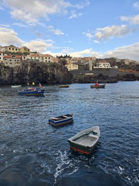 Madeira Adası 'ndaki Cmara de Lobos' ta balıkçı tekneleri, sarp kayalıkları ve gelenek ve ada cazibesiyle dolu canlı bir köy sergileniyor..