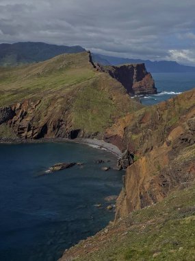  Madeiras 'taki deniz manzarası Ponta de So Loureno' nun doğu ucu. Yumuşak dalgalar, yumuşak bulutların ve ince okyanus renklerinin altındaki karanlık kayalıklarla buluşur..