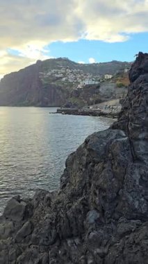 Cmara de Lobos, Madeira Adası, Portekiz. Renkli uçurum kenarı köyü ve geleneksel balıkçı tekneleriyle manzaralı körfez. Büyüleyici, tarihi bir sahil kasabası..