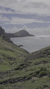 Dik volkanik kayalıklar, Baa dAbra, Ponta de So Loureno, Madeira 'nın kayalık kıyılarına düşer. Saf toprak ve yemyeşil tepeler tarafından çerçevelenmiş sakin bir Atlantik Koyu.