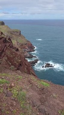 Ponta de So Loureno, Madeira 'daki dramatik kayalıklar ve volkanik arazi. Gök mavisi dalgalar engebeli kıyı yollarının altına çarpar..