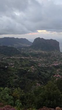 Penha de guia, Madeira 'daki Faial ve Porto da Cruz' un önünde gururla duruyor. Engebeli volkanik tepe, çarpıcı bir gökyüzünün altında Atlantik Okyanusu 'yla buluşup çarpıcı bir ada manzarası yaratıyor..
