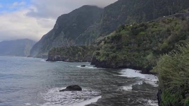 Dik yeşil kayalıklar, Madeiras boyunca Atlantik Okyanusu 'na çarpıcı kuzey sahilleri boyunca uzanıyor. Volkanik güçler ve kıyı aşınması tarafından şekillendirilmiş kasvetli ve uzak bir manzara..