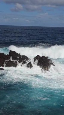 Madeira Adası 'ndaki Porto Monizs volkanik kıyı şeridi manzarası. Siyah lav oluşumları ve turkuaz dalgalar birleşerek Portekiz 'in en ikonik okyanus manzaralarından birini oluşturur..