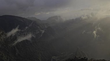 Madeira 'nın yukarısında Pico do Arieiro sabah güneşinin tadını çıkarıyor. Altın ışınlar ve sürüklenen bulutlar doğal güzelliklerle dolu büyülü, sıcak bir dağ anı yaratır..