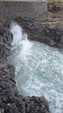 Atlantik dalgaları Porto do Cruz, Madeira 'daki kıyı kayalıklarından püskürüyor. Volkanik kayalıklar ve sert deniz enerjisiyle şekillenen şaşırtıcı bir doğal güç gösterisi..