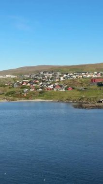 Trshavn, Faroe Adaları 'nın modern limanı: cam ofisler ve taştan rıhtımlar açık bir Kuzey Atlantik gökyüzü altında rüzgar türbinleriyle kaplı çimenli tepelere kurulmuş..