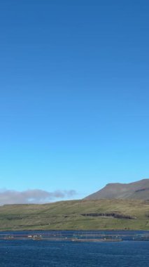 Atölye, Faroe Adaları 'ndaki sakin bir körfezde somon ağıllarının etrafında dönüyor.