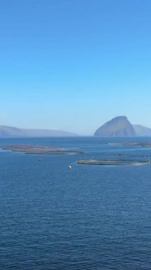 Suuroy, Faroe Adaları açıklarındaki modern somon su kültürü altyapısı dairesel okyanus kalemleri ve uzak Ltla Dmun adası.