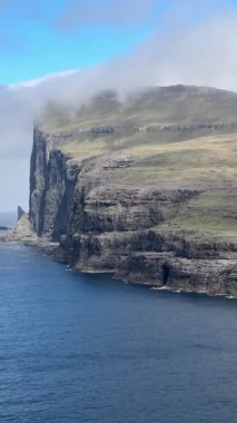 Faroe Adaları 'nın sarp deniz kayalıkları Atlantik Okyanusu' nun üzerinde sislerin içinde kaybolur. Sisli ve engebeli doğal güzellikleri olan dramatik kıyı şeridi..