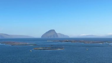 Suuroy, Faroe Adaları yakınlarındaki somon çiftliklerinin resimli görüntüsü, Atlantik suları boyunca yükselen ikonik Ltla Dmun adası.