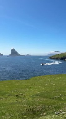 Bur, Vgar Adası 'ndan dramatik deniz manzarası. Tindhlmur ve Drangarnir sakin Faroe sularında yelken açan bir tekne gibi Atlantik ufkuna hükmediyorlar..