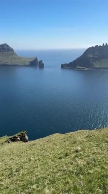 Faroe Adaları, Bur tepelerinden Tindhlmur ve Drangarnir 'in görkemli manzarası. Pürüzsüz zirveler, berrak kuzey gökyüzünün altındaki derin mavi sulardan yükselir..