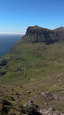 Gsadalur 'un el değmemiş manzarası. Faroe Adaları' ndaki Vgar Adası 'ndaki Atlantik kıyısından yükseliyor. Saf doğa, insan yok, sadece kara ve deniz..