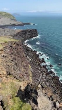 Volkanik kayalıklar Vestmannaeyjar, İzlanda 'da Atlantik' e düşüyor. Engebeli lav kayalarından, çarpan dalgalardan ve panoramik okyanus manzaralarından oluşan dramatik bir kıyı şeridi..