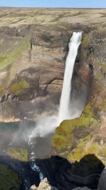 Hekla, İzlanda 'daki Fossrdalur Vadisi' ndeki Hifoss şelalesi. Dramatik kayalıklar, bazalt katmanları ve yemyeşil yosunlar İzlanda 'nın en yüksek şelalelerinden birini oluşturuyor..