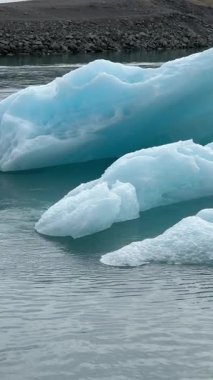 İzlanda 'nın ikonik JkulsrIn Göl' ünde Vatnajkull Buzulu 'ndan yavaşça süzülen buzdağları sergileniyor. Kutup çölünün saf güzelliğini gözler önüne seriyor..