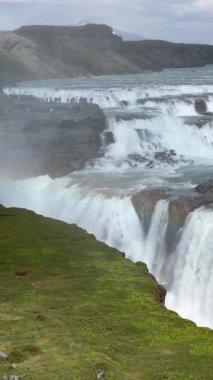 Gullfoss şelalesinin gürleyen katları İzlanda 'nın yeşil yaz manzarasıyla çevrili derin bir kanyona daldı. Altın Daire yolunda görülmesi gereken bir durak..
