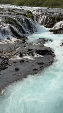 Buzullarla beslenen Brarfoss şelalesi volkanik arazide gerçeküstü mavi renkte akar ve İzlanda 'nın en fotojenik ve huzurlu nehir manzaralarından birini yaratır..