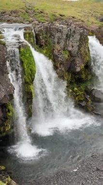 Kirkjulsfoss Şelalesi İzlanda 'da yosunlu lav kayalarının üzerinden akıyor. En ikonik şelalelerden biri, Game of Thrones 'daki ünlü Kirkjufell dağının yakınında..