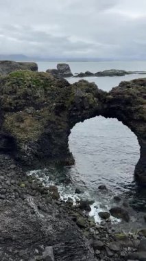 Arnarstapi, İzlanda 'daki bazalt kemerli Gatklettur. Snfellsnes 'in volkanik kıyı şeridi boyunca yüzyıllar boyunca rüzgar ve deniz tarafından şekillendirilen ikonik doğal bir yer..