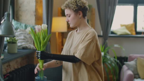 Mladá Dívka Protézou Rameno Uvedení Kytice Čerstvých Květin Vázy Obývacím — Stock video