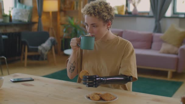 Protez Kollu Bir Kız Evdeki Mutfak Masasında Oturuyor Elinde Kurabiye — Stok video
