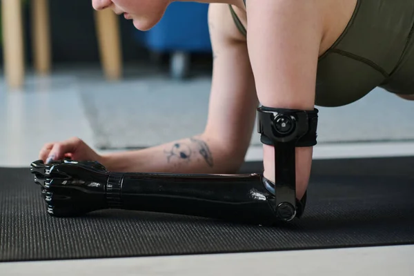 Close-up of young girl with prosthetic arm exercising on exercise mat during training