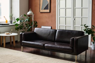 Ortasında rahat bir kanepe ve diğer modern mobilyalarla aydınlık büyük bir daire.