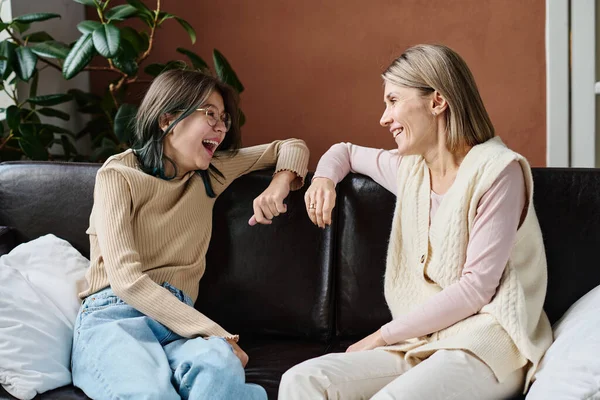 소녀가 소파에 앉아서 서로를바라보며 웃으면서 어머니와 대화를 나누는 — 스톡 사진
