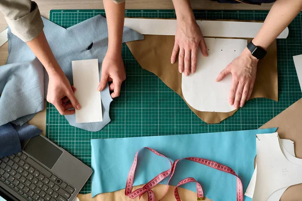 Обзор Рук Двух Кожевенных Женщин Пришивающих Бумажные Узоры Кусочкам Кожи — стоковое фото