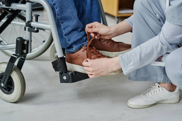 Крупный План Молодой Женщины Помогающей Мужчине Инвалидностью Завязывать Шнурки Пока — стоковое фото