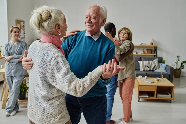 Boldog Idős Pár Táncol Együtt Szobában Másokkal Gondviselővel Háttérben — Stock Fotó