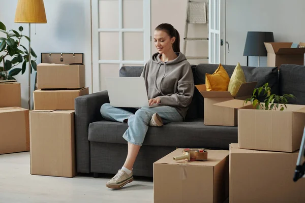 Girl Sitting Sofa Using Laptop Search Movers Her Moving New — Stock Photo, Image