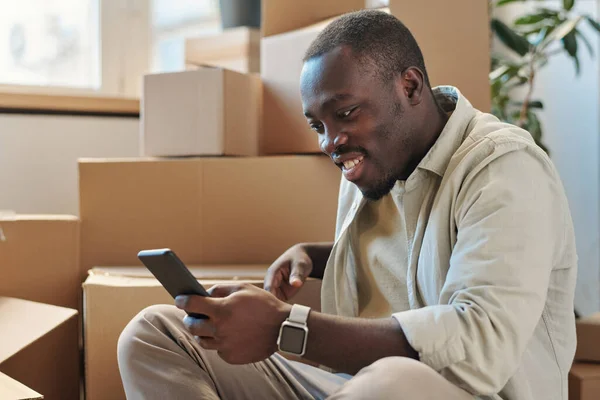 Hombre Afroamericano Hablando Línea Usando Teléfono Inteligente Sonriendo Durante Conversación —  Fotos de Stock