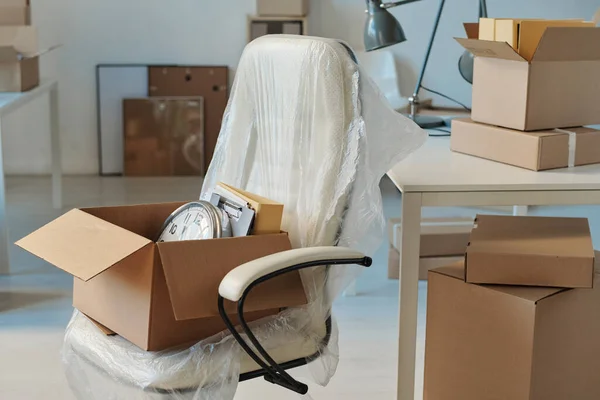 Horizontal image of new furniture and packed cardboard boxes in new big office