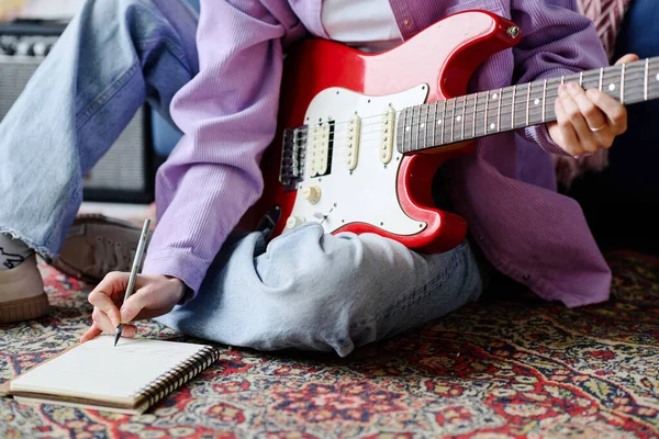 音乐人靠吉他坐在地板上谱写新歌的特写 — 图库照片