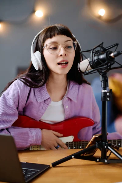 歌手的垂直形象 吉他手记录着她的歌曲 在桌上用麦克风歌唱 — 图库照片