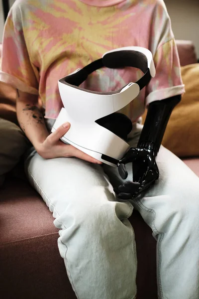 Close-up of girl with prosthetic arm using virtual reality simulator for rehabilitation