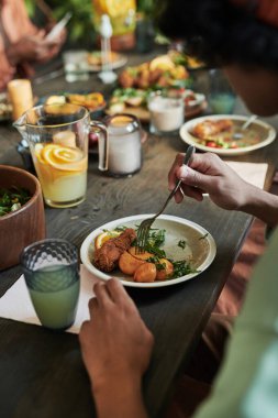 Yemek masasında oturan ve bayram yemeğinde sebzeli tavuk yiyen genç çocuğun yakın çekimi.